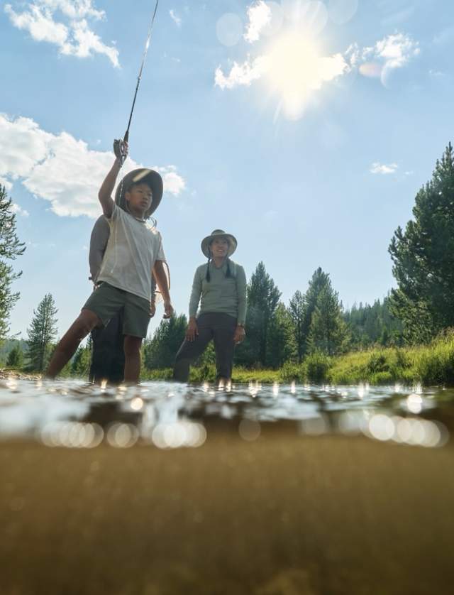 two persons standing in water fishing