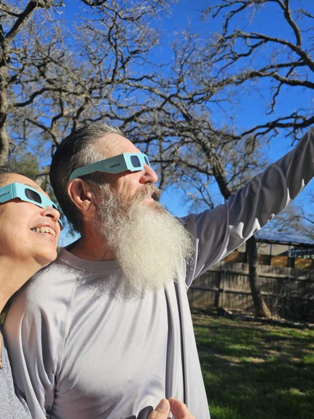 Couple looking at sky with eclipse glasses