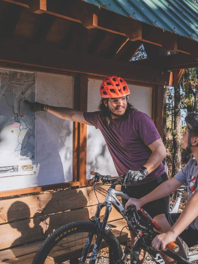 A father and son on bikes look at the trail map at Ben Geren park in Fort Smith, Arkansas.