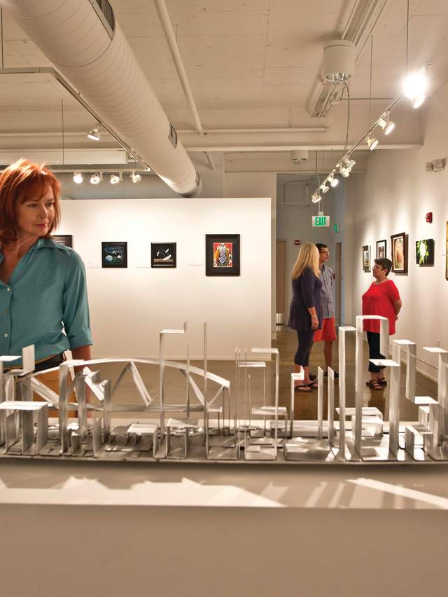 A woman enjoys a unique sculpture at the Fort Smith Regional Art Museum.