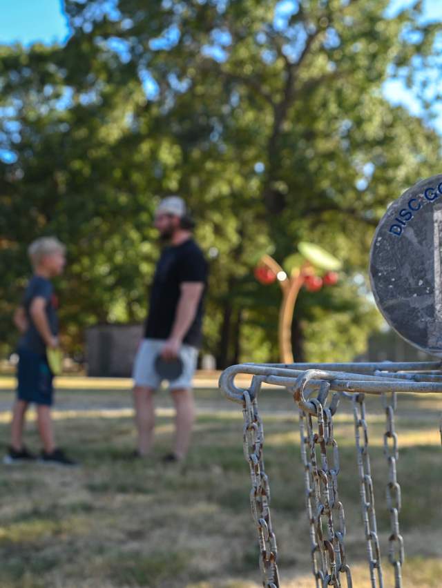 A father and son play disc golf at Tilles Park in Fort Smith.