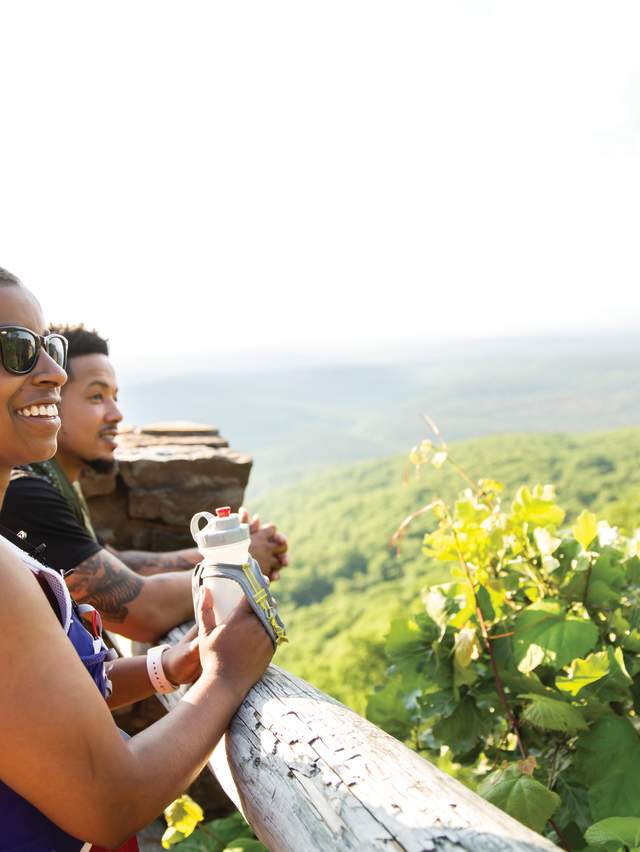 A mother and son look out over Mount Magazine State Park from a scenic overlook.