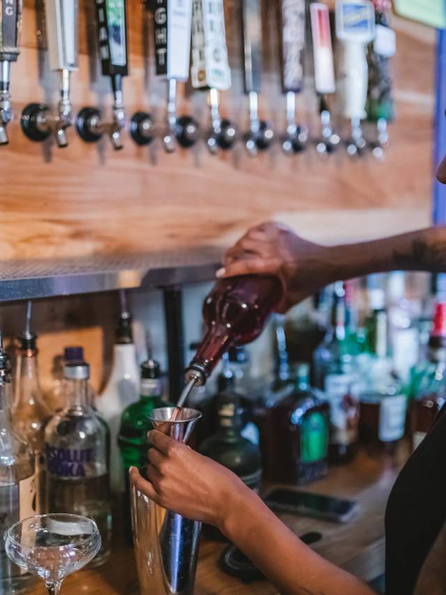 A bartender at Prohibition Bar mixes a cocktail behind the bar.