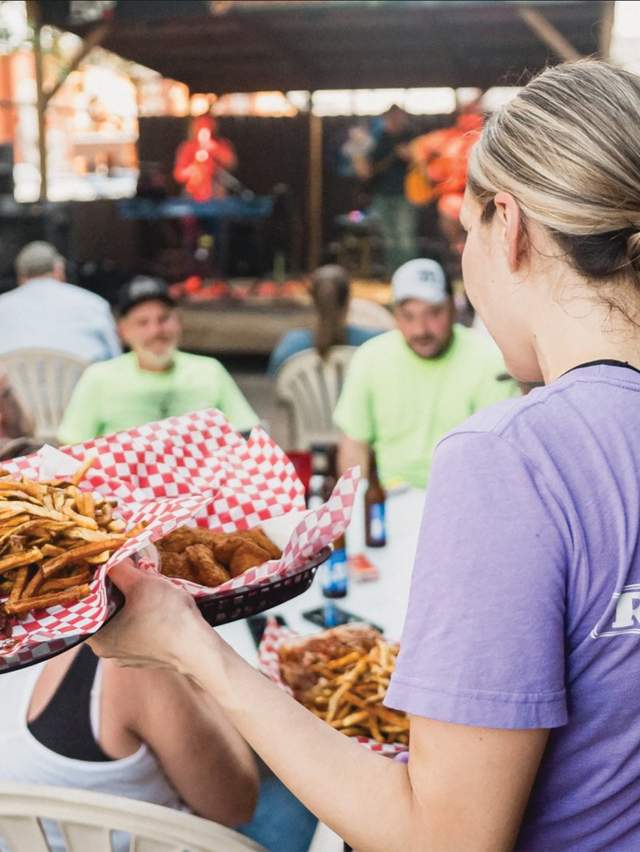 A waitress brings food out for a group at Rib Room in Fort Smith, Arkansas.