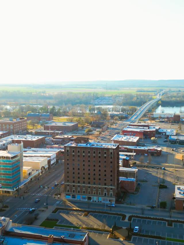 The sun peeks over the Arkansas River and bathes downtown Fort Smith in summer rays.