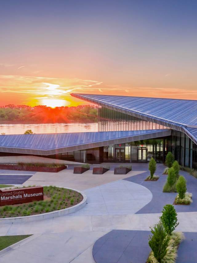 The sunsets behind the Arkansas River, framed by the U.S. Marshals Museum in Fort Smith, Arkansas.