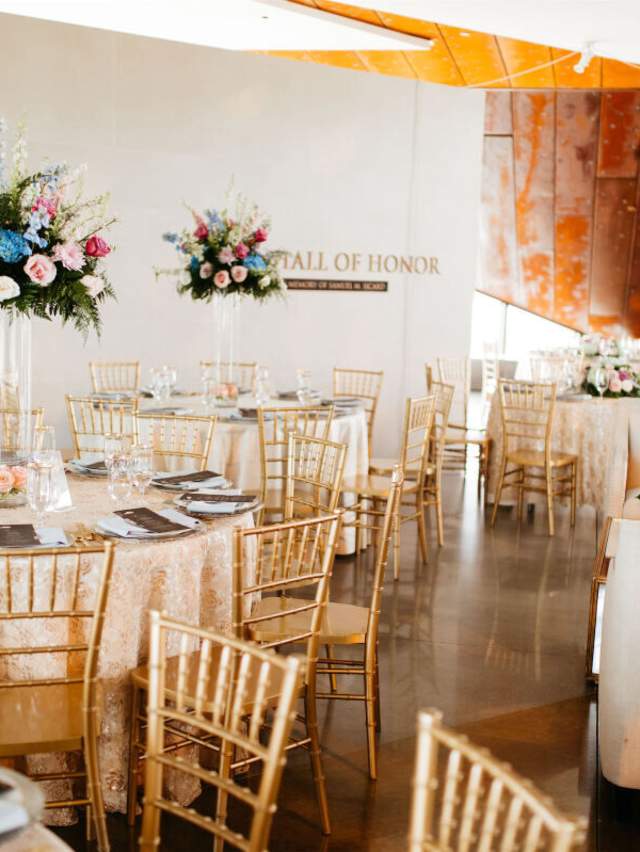 Beautiful floral arrangements sit on round tables with white tablecloths and place settings at the U.S. Marshal Museum.