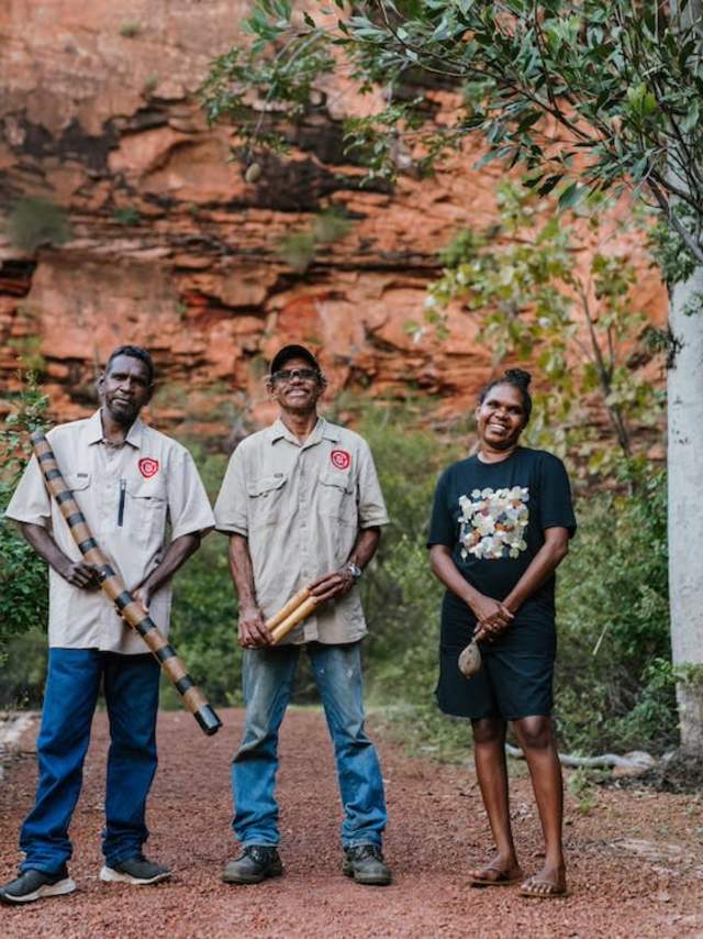 Waringarri Aboriginal Arts Tour Guides standing in Mirima National Park, holding artefacts from the art centre
