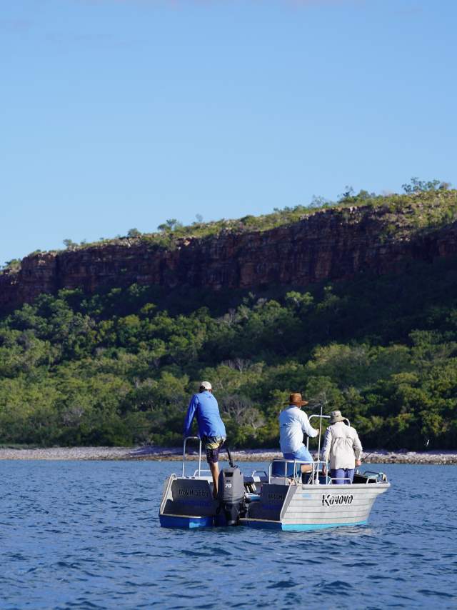 Three people on a small fishing boat on the Kimberley Coast