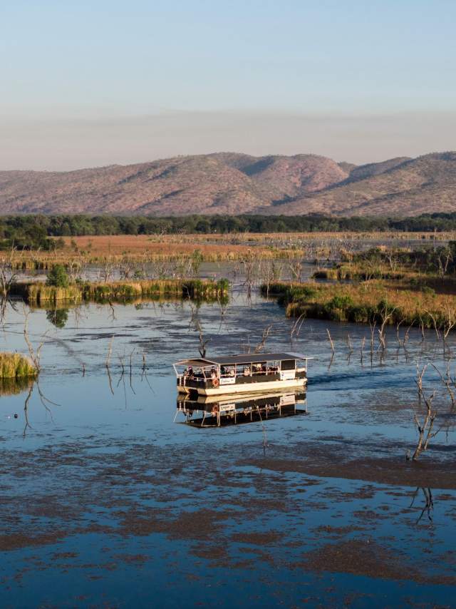 Kununurra Cruises boat on the still waters of Lake Kununurra, with ranges visible in the background