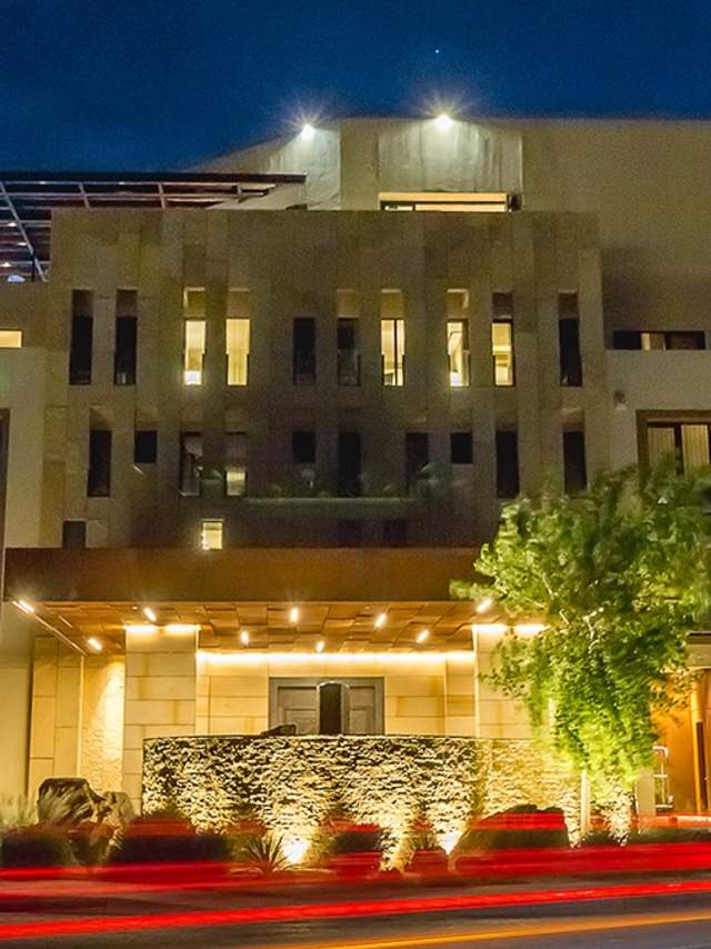 Nighttime view of the modern exterior of the Hotel Chaco, illuminated under a clear sky.
