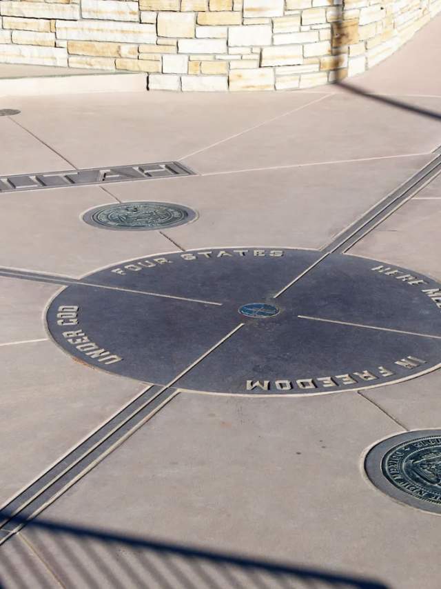 A bronze plaque on the ground showing the four corners of New Mexico