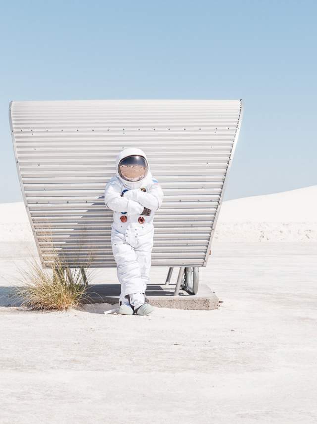 An astronaut leaning against a sun shade at White Sands National Park