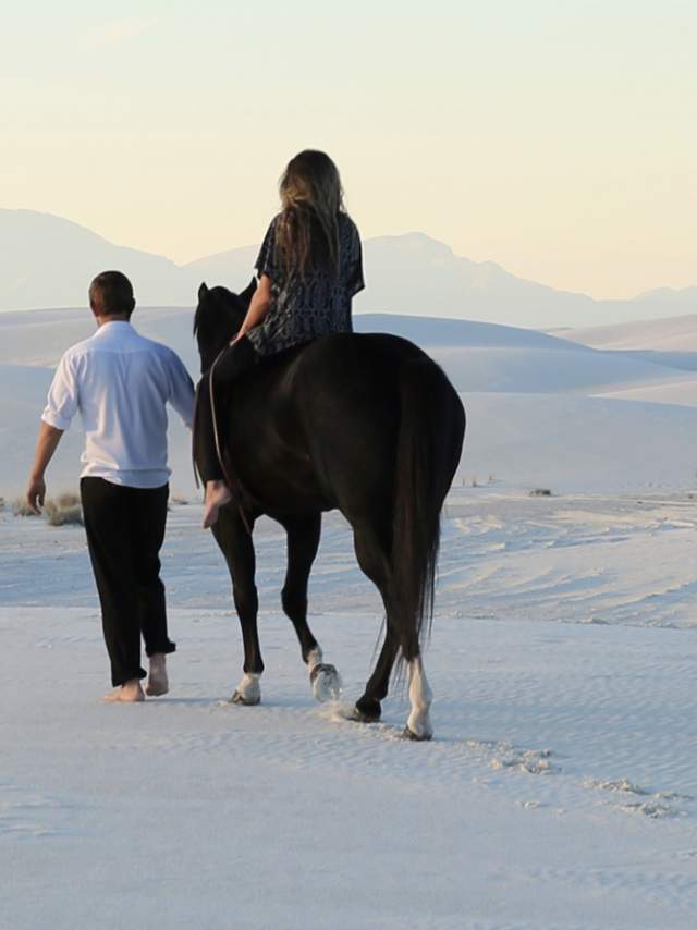 Man Walking With Woman On A Horse In Alamogordo