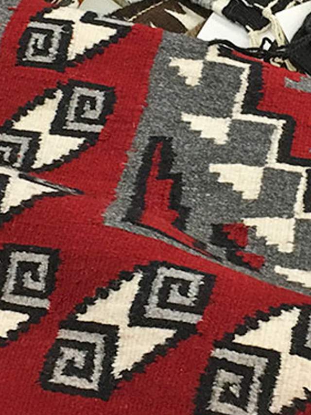 Navajo Rugs in a pile at the Crownpoint rug auction.