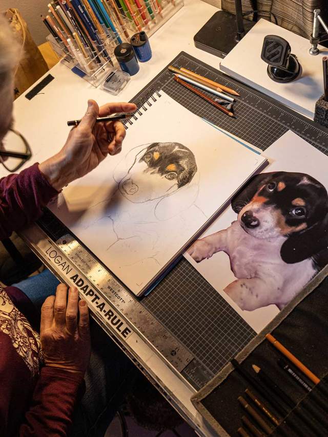 A woman painting a dog portrait