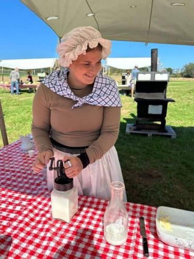 Summer Rovenolt churns butter at Heritage Days.