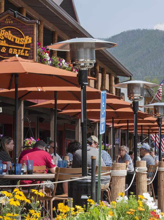 Sunny patio with diners eating at Sagebrush BBQ