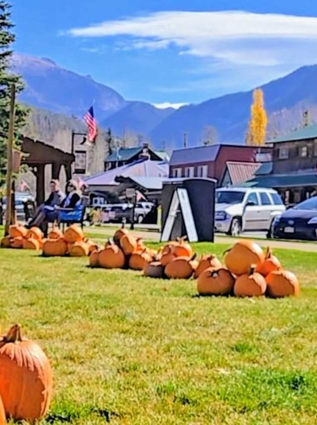 Ghosts & Gourds pumpkin patch with families and children enjoying a sunny day near a wooden building