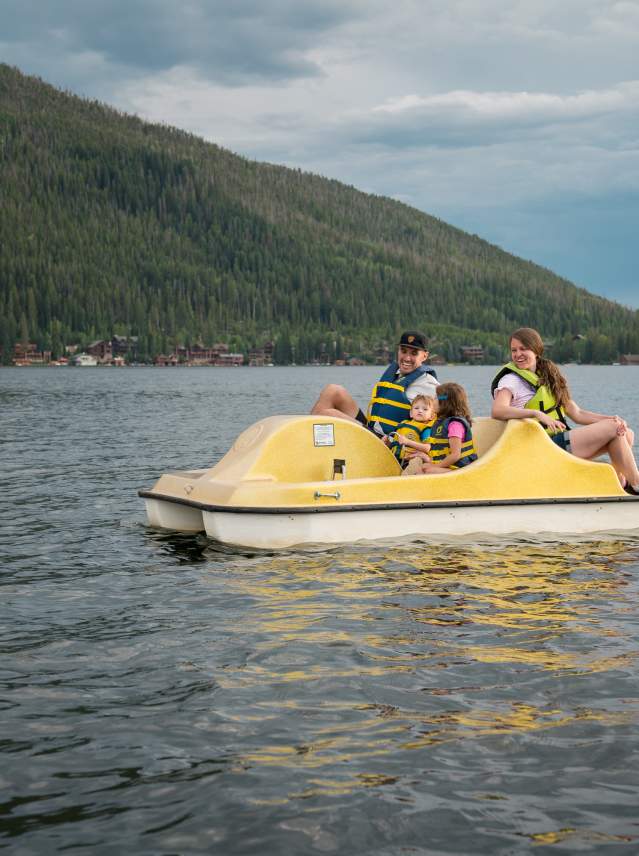 Family is happy on yellow pedal boat on grand lake