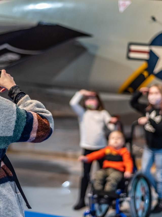 Children posing for a picture in front of an aircraft at Air Zoo