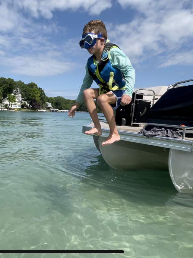 kid on the end of a boat about to jump into the water