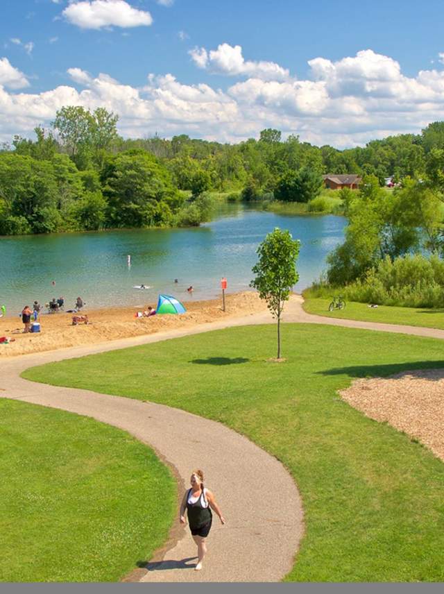 Markin Glen Park features a small playground on a green space that leads to a quiet beach and blue water.