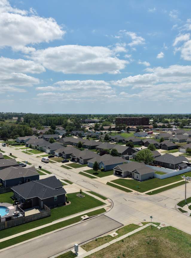 Drone image of a neighborhood in Salina, Kansas. Image shows multiple homes on a partly sunny afternoon.