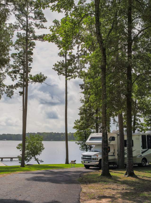 RV in Wooded Area by Water