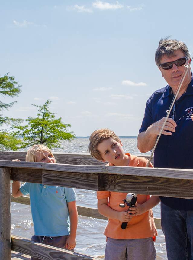 A man and his two grandsons fish off the pier on Caddo Lake