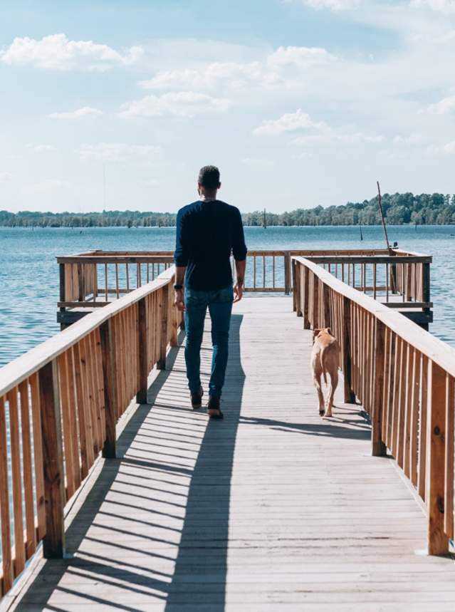 Man walks along pier at Robert A. Nance Park on Black Bayou Lake in Hosston, La