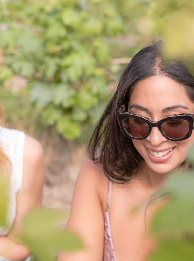 Two women sitting in a vineyard