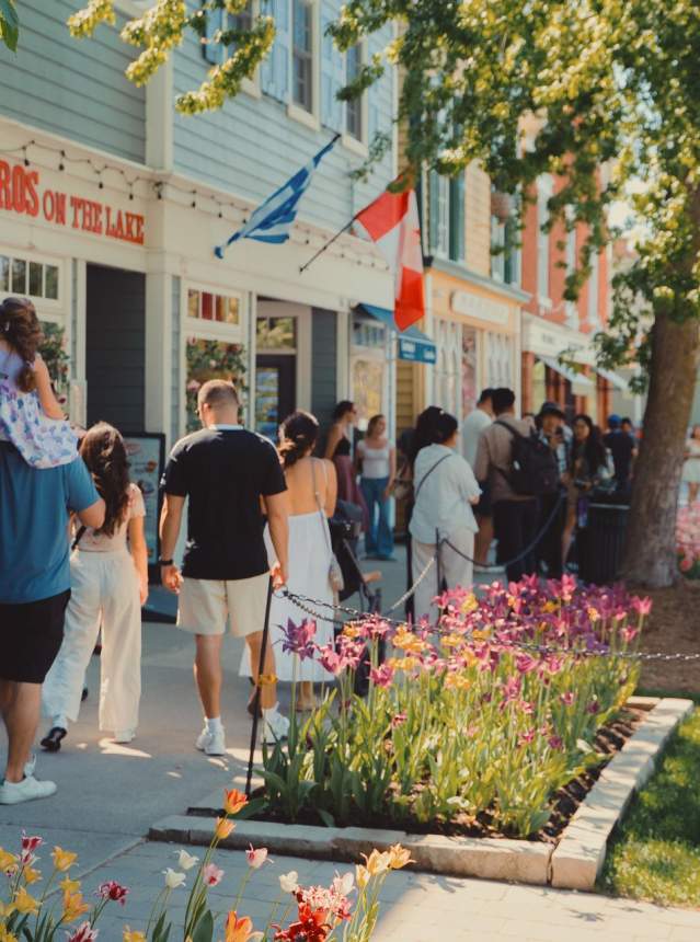 Crowd walking on sidewalk in front of heritage shops