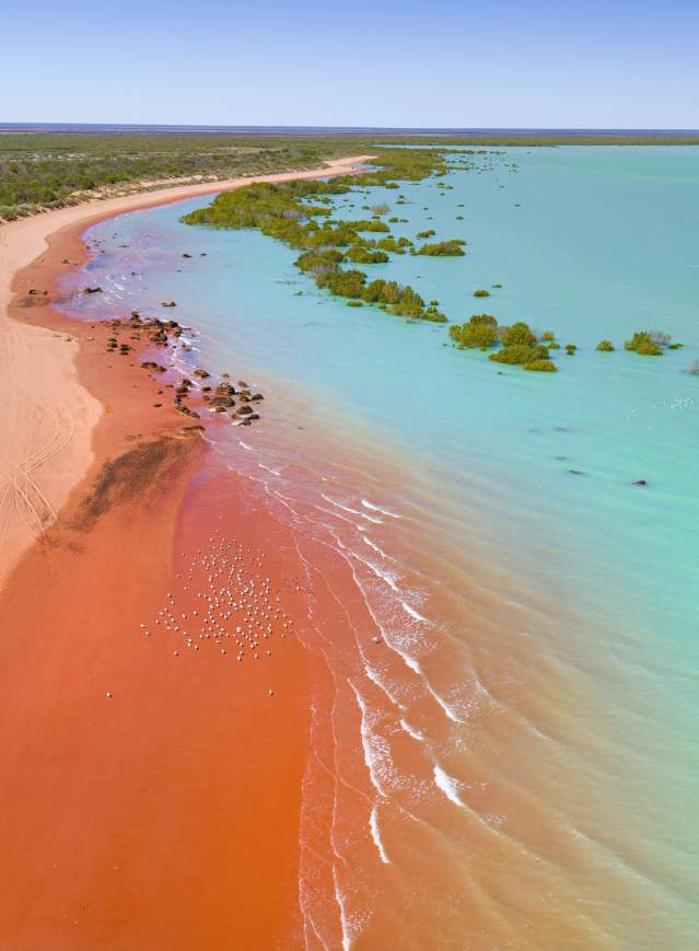 Aerial view of Roebuck Bay Broome showing the turquoise waters and pindan red stained sands