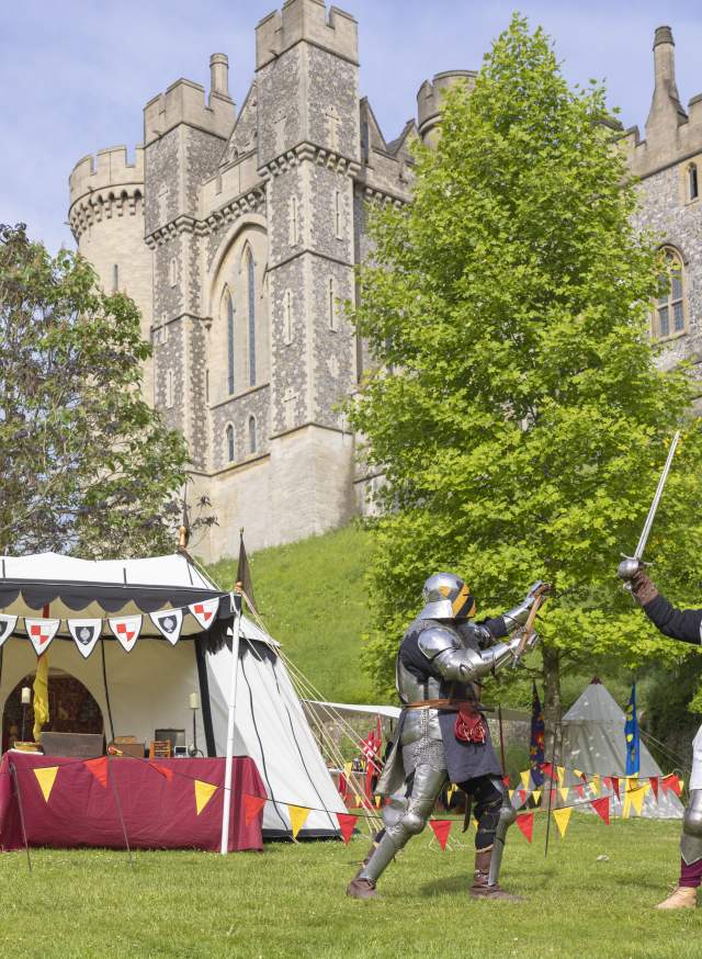 Two knights in medieval costume and armour in the grounds of Arundel Castle, Sussex