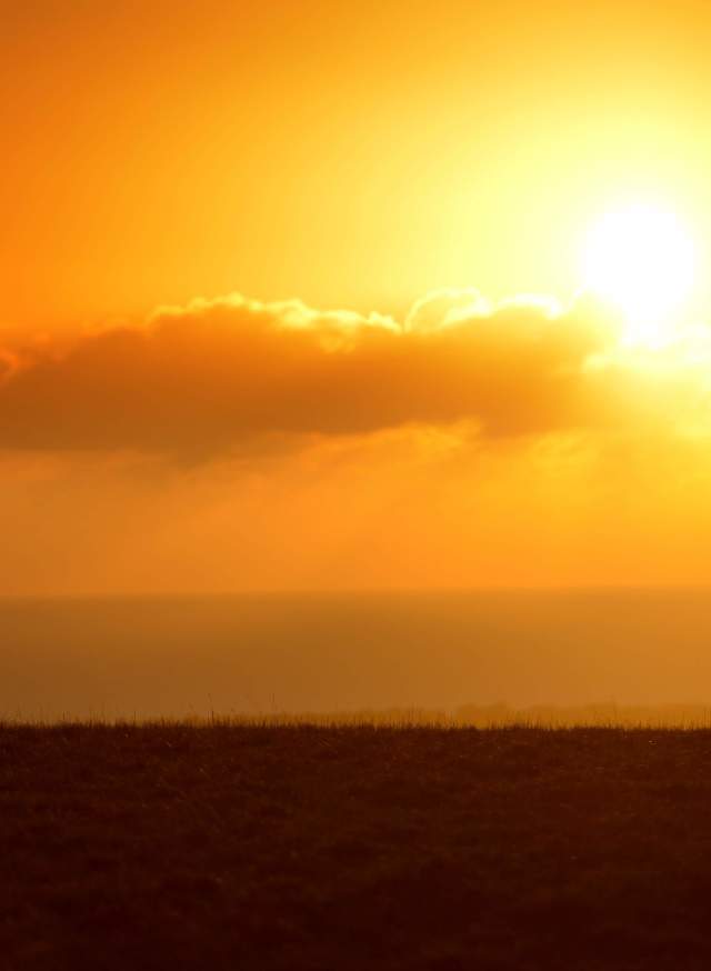 A lone walker on the South Downs in Sussex at sunset