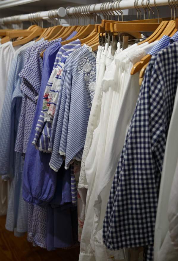 Blue and white clothing hanging up in a store.