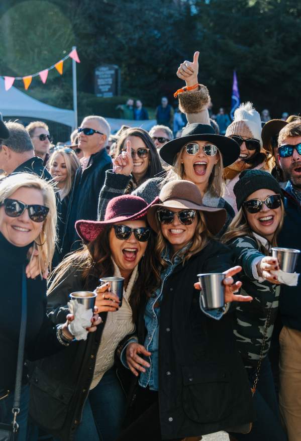 A group of people smiling at Highlands Food & Wine Festival.