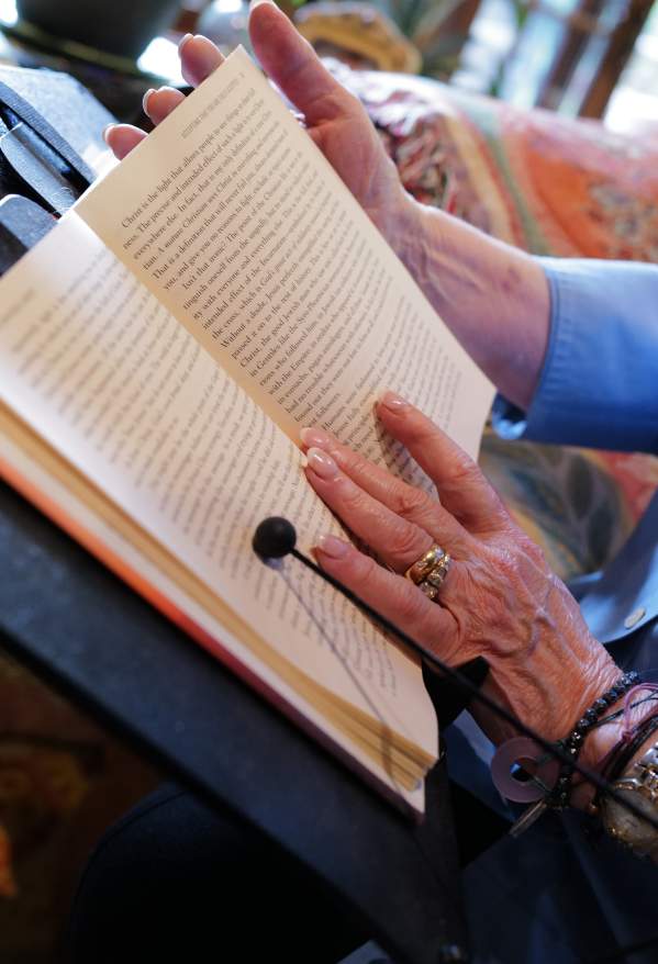 A woman's hands holding the pages of a book open to read it.