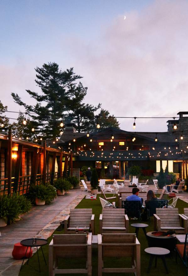 The large deck of Skyline Lodge at dusk with string lights hanging above.