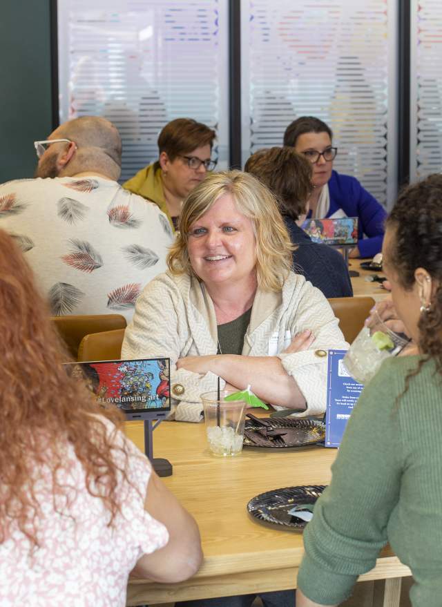 Group of people chatting at a table at Lansing Shuffle
