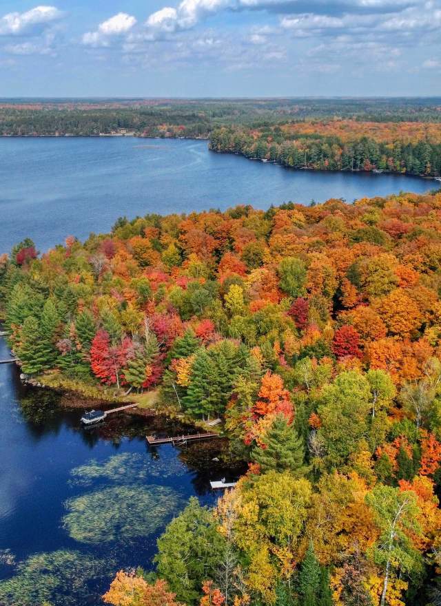 Aerial Photo of a lake and fall foliage in red orange yellow and green