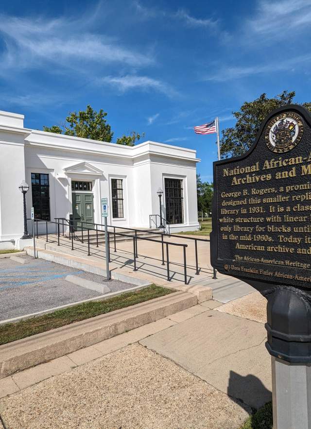 white building with an iron sign: National African American Archives and Museum