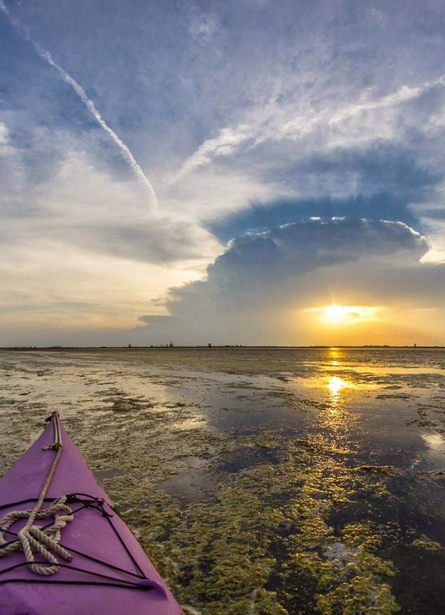 View of sunset over the water from a kayak