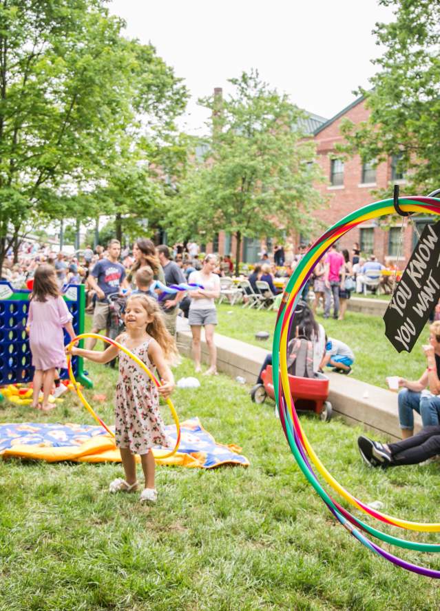 A mom taking a photo of her daughter hoola hooping at Taste of Bloomington