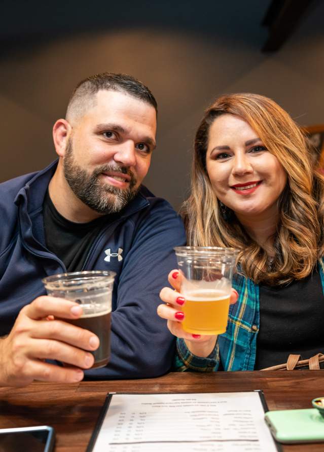 Couple poses for photo with beers at Yellow Bridge Brewing co.