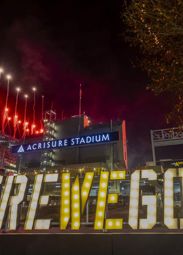 HERE WE GO letters glowing in front of Acrisure Stadium