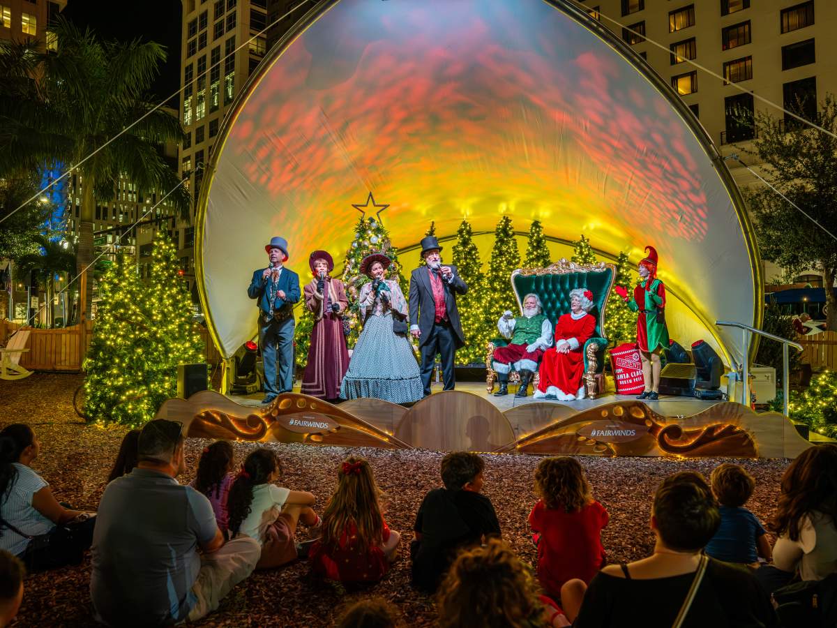 A costumed Santa figure leads a storytime presentation for guests at the Frontyard Holiday Festival at Dr. Phillips Center
