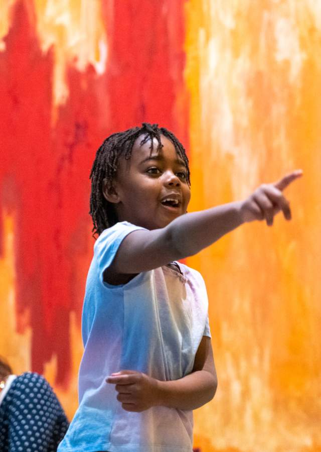 An excited young boy points at art at Clyfford Still Museum