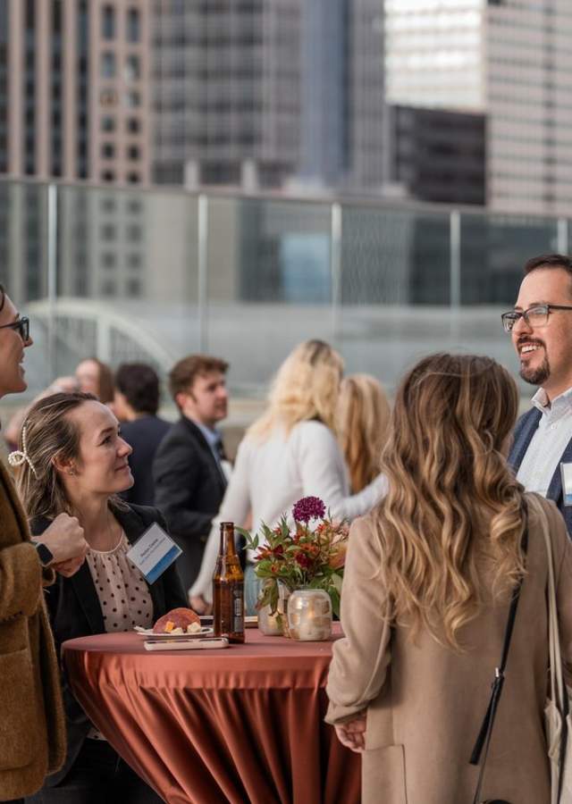 A professional groups smiles as they talk at a table at the Colorado Convention Center